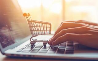 Hands typing on laptop with shopping cart, representing online shopping and digital commerce. scene captures essence of modern retail and convenience photo