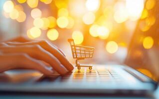 Hands typing on laptop with shopping cart icon, symbolizing online shopping and digital commerce. warm bokeh background adds festive touch photo