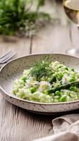 Fresh green risotto with peas and herbs served in a rustic setting during springtime photo