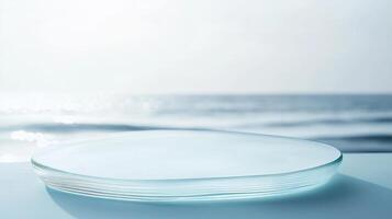 Clear glass plate resting on a surface with ocean waves gently lapping in the background under soft sunlight photo