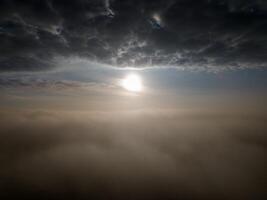 Tranquil and serene ethereal sunrise above the clouds with mist and mystery photo