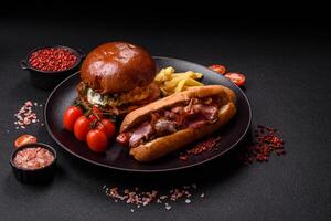 Delicious juicy hot dog with sausage, bacon, sauce, salt and spices s photo