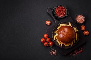 Delicious burger with beef patty, fried egg, sauce, salt and spices photo