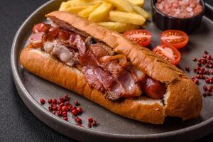 Delicious juicy hot dog with sausage, bacon, sauce, salt and spices ra photo