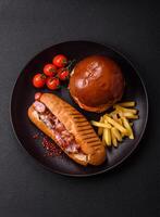Delicious juicy hot dog with sausage, bacon, sauce, salt and spices d photo