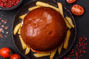 Delicious burger with beef patty, fried bacon, herbs, sauce, salt and spices photo