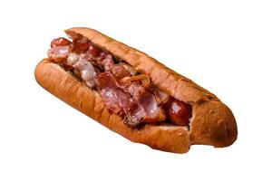 Delicious hot dog with sausage, bacon, sauce, salt and spices photo