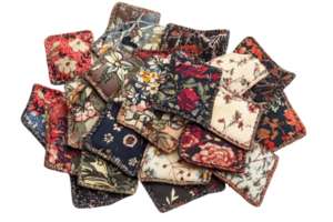 Pile of assorted floral fabric patches with vibrant colors and intricate patterns, perfect for quilting, crafting, or DIY projects. png