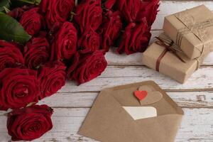 Red roses, brown paper gift boxes, paper heart, declaration of love, rustic style photo