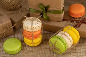 Round multi-colored meringue cookies, gifts in craft boxes made of brown paper, close-up photo