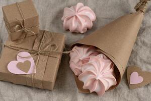 Gift in brown craft box with paper heart, pink marshmallow meringue with love photo