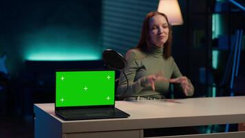 Tech expert presenting chroma key isolated screen laptop in entry level low budget price range. Gen Z influencer reviewing green screen notebook in front of internet subscribers, camera A video