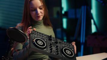 Young artist films DJ mixing tutorial in apartment studio, showing examples of sampling on sound controller. Happy entertainer shows modern musical equipment to subscribers in living room, camera A video