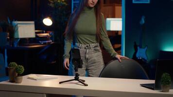Content creator arriving in studio, using smartphone on tripod to shoot introductory segment for vlog channel. Media star greeting devoted fan community, introducing today subject, camera A video