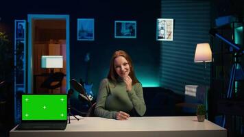 Tech expert presenting chroma key isolated screen laptop in entry level low budget price range. Gen Z influencer reviewing green screen notebook in front of internet subscribers, camera B video