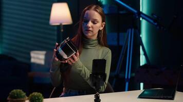 Gen Z tech expert filming sponsored content, unboxing newly released VR glasses product to make viewers buy it. Influencer presenting virtual reality headset product to audience, camera A video