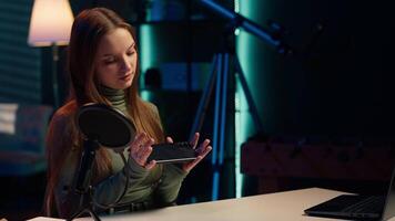 Tech specialist filming technology review of newly launched smartphone, presenting features to subscribers. Influencer advertising mobile phone to fans from home studio, camera A video