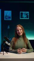 Vertical Upbeat content creator in studio filming herself discussing topics of interest for generation Z fanbase. Jolly internet star talking in microphone, recording targeting gen Z viewers, camera B video