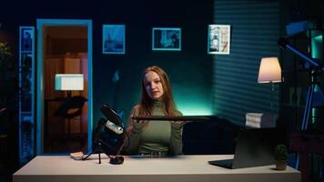 Entertainer presents keyboard and mouse from brand sponsoring , urging viewers to buy it. Young girl does influencer marketing by advertising computer peripherals to audience in studio, camera B video