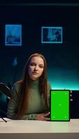 Vertical Tech guru excited to review newly released mockup tablet, comparing features with older models. Influencer filming for social media, analyzing latest generation of green screen device, camera B video