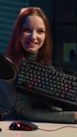 Vertical Happy influencer testing keyboard and mouse while doing review in personal studio to see if price is justified. Cheerful media star showcasing computer peripherals features to audience, camera A video