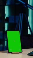 Vertical Smiling young internet star presenting green screen mockup tablet from brand sponsoring . Girl does influencer marketing by advertising chroma key isolated screen device to audience, camera A video