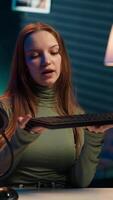 Vertical Entertainer presents keyboard and mouse from brand sponsoring , urging viewers to buy it. Young girl does influencer marketing by advertising computer peripherals to audience in studio, camera A video