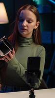 Vertical Gen Z tech expert filming sponsored content, unboxing newly released VR glasses product to make viewers buy it. Influencer presenting virtual reality headset product to audience, camera A video