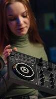 Vertical Young artist films DJ mixing tutorial in apartment studio, showing examples of sampling on sound controller. Happy entertainer shows modern musical equipment to subscribers in living room, camera A video