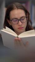 A Focused Reader is Engrossed in a Book While Comfortably Sitting in a Knowledgeable Library video