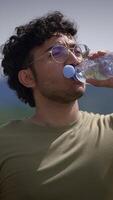 A Young Man, Full of Life, Enjoying a Refreshing Drink of Water While Surrounded by Nature video