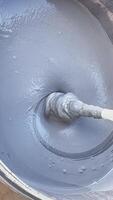 A mix of quartz wall material is being prepared with a drill attachment, ensuring an even consistency for a construction task. The process requires skill and precision video