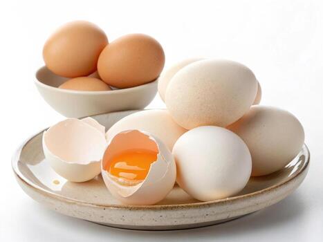 Fresh eggs stacked on plate with broken shell revealing yolk photo
