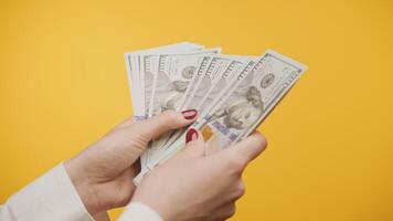 Counting Hundred Dollar Bills on Yellow Background video