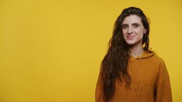 Smiling Woman Pointing to the Side on Yellow Background video