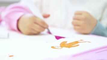 Closeup child female hand artist painter paints draws creating new art work on canvas in workshop lesson of painting enjoying process of drawing creating picture using brush applying oil paint palett video
