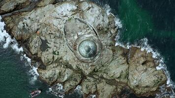 Lighthouse roof on rocky island Aerial view video