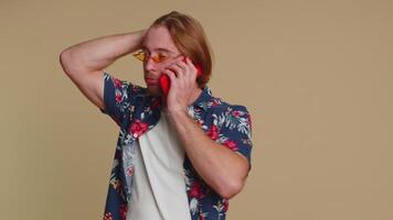 Tired sleepy man talking on mobile phone with friend, making online conversation annoyed boring talk video