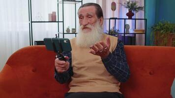 Grandfather man taking selfie on smartphone communicating call home online with subscribers video