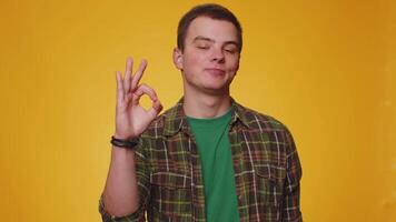 Young man looking approvingly, showing ok approve feedback gesture like sign positive something good video