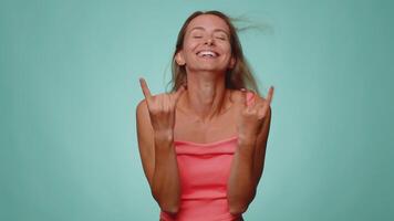 Overjoyed happy woman showing rock n roll gesture by hands, cool sign, shouting yeah with crazy face video