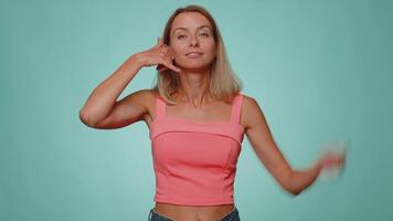 Cheerful one woman in crop top looking at camera doing phone gesture like says hey you call me back video