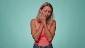 Woman touching cheek suffering from toothache cavities or gingivitis waiting for dentist appointment video