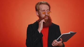 Thoughtful journalist man making notes, writing down thoughts with pen into notepad notebook diary video