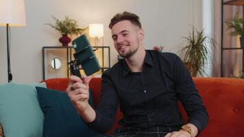Man blogger influencer taking selfie on smartphone, make virtual social media online at home video