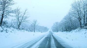 footage of a snowstorm as seen from inside a car driving on a snowy road in winter video