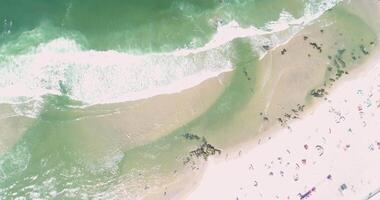shore of a beach with people enjoying the summer, zenithal footage with drone video