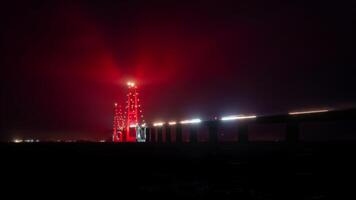Traffic on the Great Belt Bridge in Denmark illuminated in red due to Christmas. A night time lapse clip video
