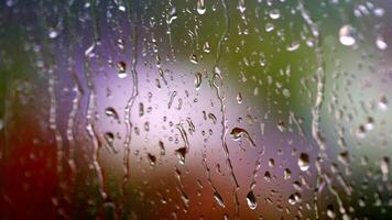 Raining weather. Rain droplets flowing on glass surface. Raindrops falling down on the window glass. Water drops on window. video
