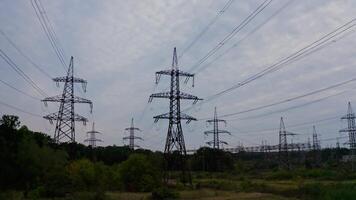 High voltage electricity towers. Power lines at green field in a summer day. Electricity distribution station. View from below. video